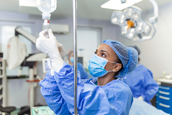 An anaesthetist preparing an IV line in theatre