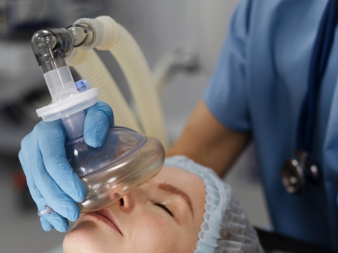 Patient with eyes closed receiving anaesthetic mask